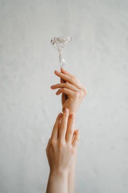 Hafif arka planda beyaz çiçekli bir kadın eli