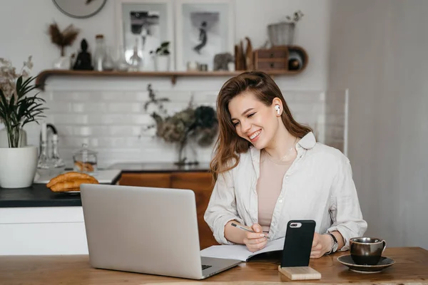 Menina loira alegre sorrindo e conversando via videochamada no laptop, home office, trabalhando remotamente, explicando uma estratégia, freelancer, discutindo um novo projeto com a equipe — Fotografia de Stock