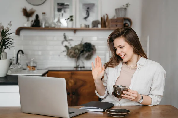 Mulher sorrindo trabalhando com laptop beber café, trabalhando em casa, educação remota — Fotografia de Stock