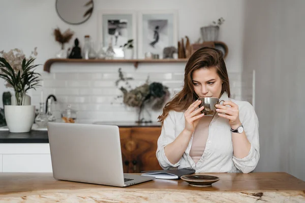 Mulher sorrindo trabalhando com laptop beber café, trabalhando em casa, educação remota — Fotografia de Stock