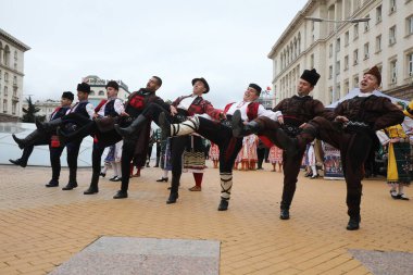Sofya, Bulgaristan - 19 Nisan 2021: Geleneksel halk kostümlü insanlar Bulgaristan 'ın başkenti Sofya' da 