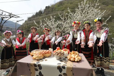 Gara Bov, Bulgarya- 24 Nisan 2021: Kızlar saçlarını renkli ve zengin bir şekilde süslüyor ve köyde dolaşıp şarkılar söyleyip dans ediyorlar, bu şekilde evlenmeye hazır olduklarını gösteriyorlar.
