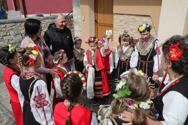 Gara Bov, Bulgarya- 24 Nisan 2021: Kızlar saçlarını renkli ve zengin bir şekilde süslüyor ve köyde dolaşıp şarkılar söyleyip dans ediyorlar, bu şekilde evlenmeye hazır olduklarını gösteriyorlar.