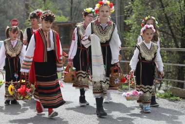 Gara Bov, Bulgarya- 24 Nisan 2021: Kızlar saçlarını renkli ve zengin bir şekilde süslüyor ve köyde dolaşıp şarkılar söyleyip dans ediyorlar, bu şekilde evlenmeye hazır olduklarını gösteriyorlar.