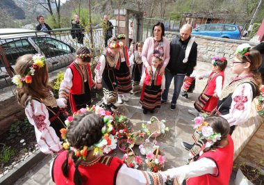 Gara Bov, Bulgarya- 24 Nisan 2021: Kızlar saçlarını renkli ve zengin bir şekilde süslüyor ve köyde dolaşıp şarkılar söyleyip dans ediyorlar, bu şekilde evlenmeye hazır olduklarını gösteriyorlar.