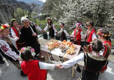 Gara Bov, Bulgarya- 24 Nisan 2021: Kızlar saçlarını renkli ve zengin bir şekilde süslüyor ve köyde dolaşıp şarkılar söyleyip dans ediyorlar, bu şekilde evlenmeye hazır olduklarını gösteriyorlar.