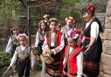 Gara Bov, Bulgarya- 24 Nisan 2021: Kızlar saçlarını renkli ve zengin bir şekilde süslüyor ve köyde dolaşıp şarkılar söyleyip dans ediyorlar, bu şekilde evlenmeye hazır olduklarını gösteriyorlar.