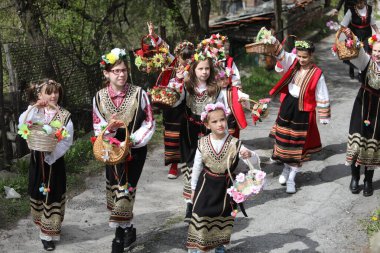 Gara Bov, Bulgarya- 24 Nisan 2021: Kızlar saçlarını renkli ve zengin bir şekilde süslüyor ve köyde dolaşıp şarkılar söyleyip dans ediyorlar, bu şekilde evlenmeye hazır olduklarını gösteriyorlar.