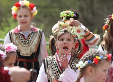 Gara Bov, Bulgarya- 24 Nisan 2021: Kızlar saçlarını renkli ve zengin bir şekilde süslüyor ve köyde dolaşıp şarkılar söyleyip dans ediyorlar, bu şekilde evlenmeye hazır olduklarını gösteriyorlar.