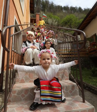 Gara Bov, Bulgarya- 24 Nisan 2021: Kızlar saçlarını renkli ve zengin bir şekilde süslüyor ve köyde dolaşıp şarkılar söyleyip dans ediyorlar, bu şekilde evlenmeye hazır olduklarını gösteriyorlar.