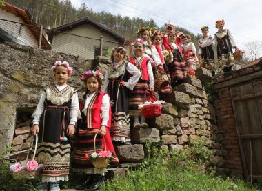 Gara Bov, Bulgarya- 24 Nisan 2021: Kızlar saçlarını renkli ve zengin bir şekilde süslüyor ve köyde dolaşıp şarkılar söyleyip dans ediyorlar, bu şekilde evlenmeye hazır olduklarını gösteriyorlar.