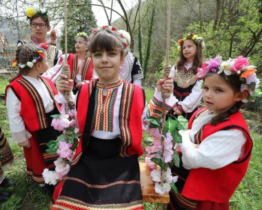 Gara Bov, Bulgarya- 24 Nisan 2021: Kızlar saçlarını renkli ve zengin bir şekilde süslüyor ve köyde dolaşıp şarkılar söyleyip dans ediyorlar, bu şekilde evlenmeye hazır olduklarını gösteriyorlar.