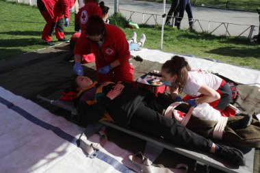 Sofya, Bulgaristan - 26 Nisan 2021: Bulgar Kızılhaç örgütünden gönüllüler bir itfaiye teşkilatıyla eğitime katıldılar. Deprem ve yangından sonra insanlara ilk yardım sağlıyorlar.