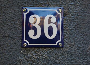 Eski model, kare, paslı, paslı bir plaka. Adres numarası da var. Yaklaş, marka..