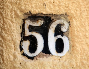 Eski model, kare, paslı, paslı bir plaka. Adres numarası da var. Yaklaş, marka..