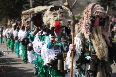 Zemen, Bulgaristan - 15 Mart 2025: Bulgaristan 'ın Zemen kentinde maskeli balo festivali Surva. Kukeri adındaki maskeli insanlar dans ediyor ve kötü ruhları korkutmak için gösteri yapıyorlar..