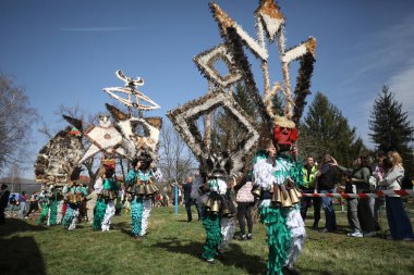 Zemen, Bulgaristan - 15 Mart 2025: Bulgaristan 'ın Zemen kentinde maskeli balo festivali Surva. Kukeri adındaki maskeli insanlar dans ediyor ve kötü ruhları korkutmak için gösteri yapıyorlar..