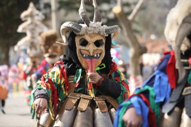 Zemen, Bulgaristan - 15 Mart 2025: Bulgaristan 'ın Zemen kentinde maskeli balo festivali Surva. Kukeri adındaki maskeli insanlar dans ediyor ve kötü ruhları korkutmak için gösteri yapıyorlar..