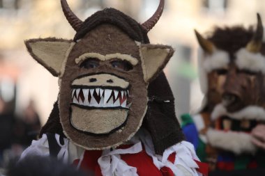 Zemen, Bulgaristan - 15 Mart 2025: Bulgaristan 'ın Zemen kentinde maskeli balo festivali Surva. Kukeri adındaki maskeli insanlar dans ediyor ve kötü ruhları korkutmak için gösteri yapıyorlar..
