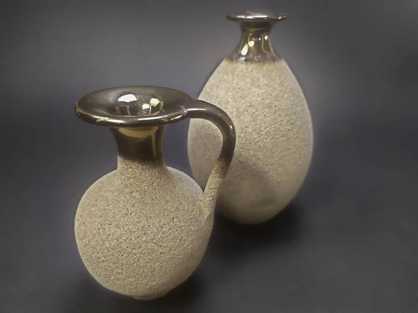 Ev dekorasyonu - çeşitli nötr vazolar koyu arkaplan üzerinde altın bir boyun