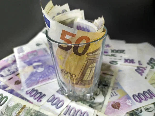 暗い背景の様々なチェコの紙幣に建てられたガラスのユーロ紙幣 ロイヤリティフリーのストック画像
