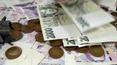 Arka planda diğer Çek para ve paralarıyla birlikte iki bin kron banknot çeviren bir erkeğin görüntüsü