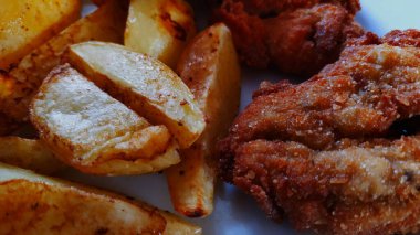 Yakından bakınca fırında patates ve kızarmış domuz pirzolası servis edilmeye hazır yemek, güzel bir tat, fotoğraf.