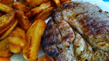 Yakından bakınca fırında patates ve kızarmış domuz boynu servis edilmeye hazır yemek, fotoğraf.