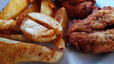 Yakından bakınca fırında patates ve kızarmış domuz pirzolası servis edilmeye hazır yemek, fotoğraf.