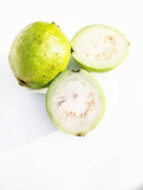 Guava, beyaz arka planda yeşil dilimlenmiş guava meyvesi.