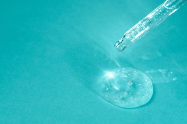 Yüz serumlu damlatıcı ve turkuaz arka planda baloncuklarla yakın plan. Sıvı antibakteriyel jöleli boru. Tıbbi araştırma makro konsepti. Hyaluronik asit, cilt bakım ürünü. Boşluğu kopyala