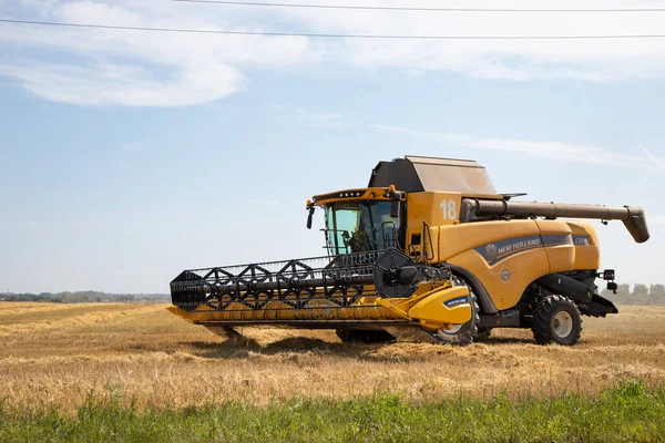 Cosechadora cosechadora New Holland cosecha trigo maduro. — Foto de Stock