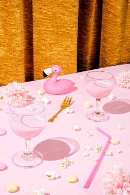 Altın çatallı minimal parti konsepti, şarap kadehlerinde pembe içecek, flamingo ve patlamış mısır her yerde pembe masa arkaplanı ve altın ipek ya da saten kumaş perde.