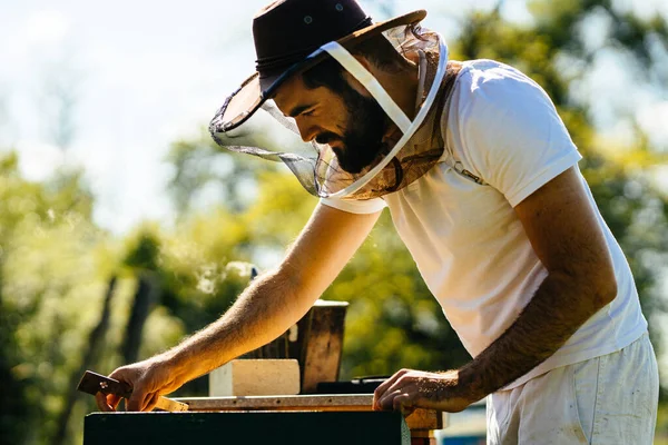彼の手にミツバチナイフで蜂の巣を検査保護カウボーイハット髭養蜂家の肖像画 いい夏の日だ — ストック写真