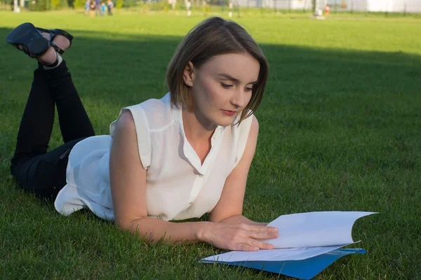 Девушка в парке с документами — стоковое фото