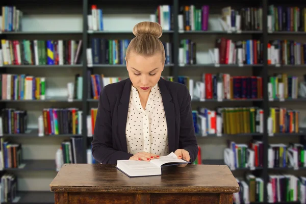 Young girl reading a book in a library — Stock Photo, Image