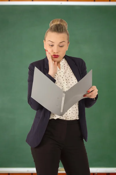 Dissatisfied business woman on the background of school board — Stock Photo, Image