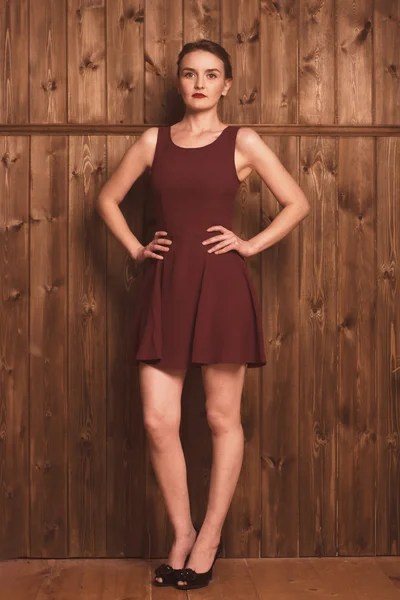 Beautiful girl on a background of a wooden wall — Stock Photo, Image