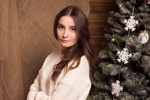 Mooi meisje in een trui ingericht kerstboom — Stockfoto