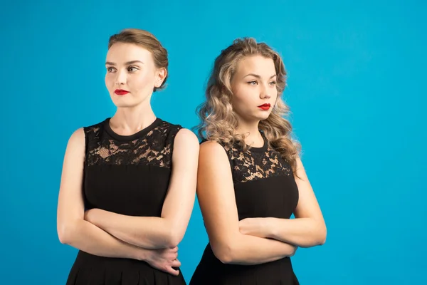 Two women in identical dresses are angry at each other