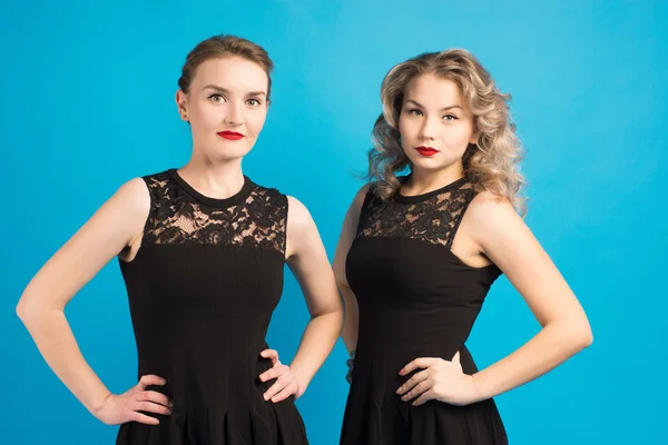 Two beautiful girls in the same black dress — Stock Photo, Image