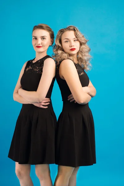 Two beautiful girls in the same black dress — Stock Photo, Image