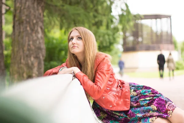 Portrait of a beautiful girl on a park bench — Stock Photo, Image