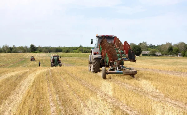 Traktor plogar ska plöja fältet — Stockfoto