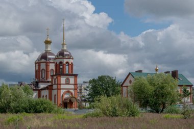 Tanrı 'nın Ortodoks Kilisesi' nin kahverengi kompleksinin arkasında çan kulesi ve kule var. Yuvarlak ve yaldızlı Ortodoks haçları var. Sağdaki pazar okulu. KALINGRAD, RUSYA, 13 HAZİRAN, 2020