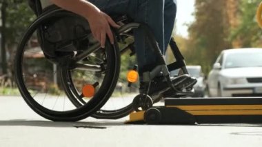 Engelliler için tekerlekli sandalyede araç kullanan bir adam. Engelliler için kaldırma ekipmanı. Tekerlekli sandalyedeki adam aracın yanında.