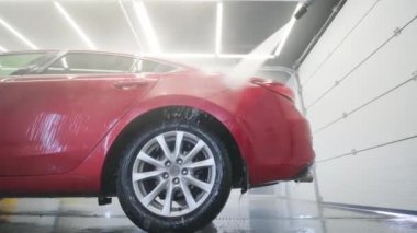 Araba yıkama köpüklü ve yüksek basınçlı suyla. Kırmızı araba.