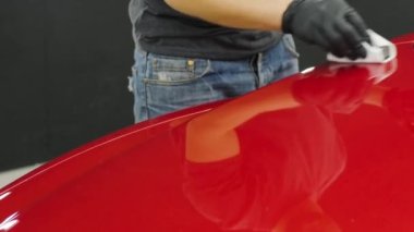 Araba servisi çalışanı bir araba detayına nano kaplama uyguluyor..