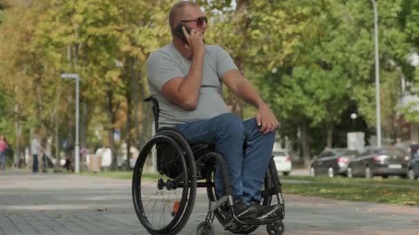 골목에서 휠체어를 장애인 스마트폰을 사용하는 — 비디오