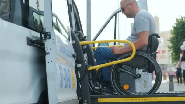 坐轮椅的男子在为残疾人提供的车辆的电梯上 残疾人士起重设备 在车前轮椅上的人 — 图库视频影像